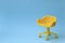 Concept of vacant chair. Yellow stool on blue clean background. Photo in minimal style