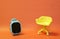 Concept of vacant chair. Yellow stool with blue kid smart watch on orange clean background. Photo in minimal style