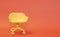 Concept of vacant chair. Yellow stool on orange clean background. Photo in minimal style