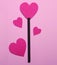 The concept of Valentine`s Day. A black wand with a heart and hearts next to it.