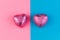 Concept of Valentine`s Day and LGBT relationships. Two heart-shaped chocolates in a pink wrapper. The background is divided in