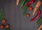 Concept of vegetables on a wooden brown background. Green cucumber and tomatoes on a wooden table. Carrot and paprika with greens.