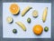 Concept vegetarian food, fresh appetizing fruit, lime, oranges, mini bananas, lined on blue background, vitamins, top view