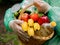 The concept of volunteer food delivery in bad weather conditions. Close-up of a basket of food in the hands of a woman