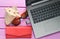 The concept of web work at a resort, freelancing. Laptop, flash drive, sunglasses, shell, purse on a violet color wooden table.