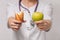 The concept of weight loss of food choice. A nutritionist holds bread and an apple in a woman`s hands