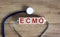 Concept word `ECMO, Extra Corporeal Membrane Oxygenation` on cubes on a beautiful wooden background. Stethoscope. Copy space,