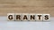 Concept of the word grants on cubes on a wooden background