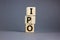 Concept word `IPO, initial public offering` on cubes on a beautiful grey background. Business concept. Copy space
