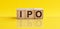Concept word IPO - Initial Public Offering - on cubes on a beautiful yellow background