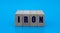 Concept word IRON on cubes on a blue background