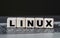 Concept word LINUX on cubes on the background of a laptop