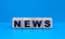 concept word NEWS on cubes on a blue background