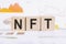 Concept word NFT on wooden cubes. NFT - short for Non Fungible Token