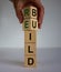 Concept word `rebuild` on cubes on a beautiful wooden table. Male hand. White background. Business concept. Copy space