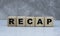 Concept word recap on wooden cubes on a gray background