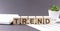 Concept word TREND on the wooden blocks on the gray background from green flower and chart