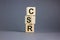 Concept words `CSR, corporate social responsibility` on cubes on a beautiful grey background. Business concept. Copy space