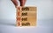Concept words `news, north, east, west, south` on wooden cubes and blocks on a beautiful white background. Male hand. Copy space