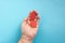 The concept of the World Blood Donor and Hemophilia Day. Two red paper drops of blood in the hand on a blue background