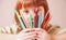 Concept: World of color. Humorous photo of great artist. Portrait of cute little child girl with colored pencils