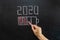 Concept for the year ending 2020, Hand draws a battery with charge indicators on a chalk Board