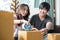 Concept young couple moving house. Asian young couple unpack cardboard box after moving in new house