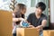 Concept young couple moving house. Asian young couple unpack cardboard box after moving in new house.