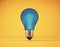 Conceptual blue bulb on yellow background. Originality, insight, and transformation