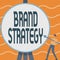 Conceptual caption Brand Strategy. Word for Longterm plan for the development of a successful brand Man Standing Holding