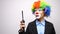 Conceptual clown in business suit firing a lighter