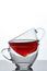 Conceptual composition of two glass teacups over white background, close-up, vertical.