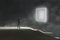 Conceptual digital art picture of a hooded man standing in front of a glowing square portal on a dark misty night