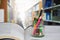 Conceptual education.Colored pencils in glass bottles on books.Graduates read books in the library.Choose focus and blur the