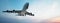 Conceptual flying white passenger jetliner or commercial plane after take off rising over a beautiful sky background