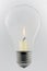 Conceptual glass light bulb with burning candle