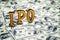 Conceptual golden abbreviation of IPO standing or lying on money dollars banknotes background. 3D Render.