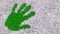 Conceptual green grass handprint on gravel background