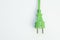 Conceptual green plug on white background, ecological green energy, copy space