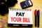 Conceptual hand writing text caption showing Pay Your Bill. Business concept for Payment for Goverment written on notebook book on