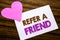 Conceptual hand writing text showing Refer A Friend. Concept for Referral Marketing written on sticky note paper, wooden wood back