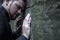 Conceptual image: hopelessness, depression, anxiety and frustration. Stressed  sad man leans  leans on the cold stone wall