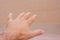 Conceptual open hand reaching out on soft orange background. Openness, pressing ahead, assistance and helping concepts