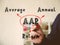 Conceptual photo about AAR Average Annual Return . Hand holding a marker pen to write on officce background