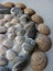 Conceptual photo of a circular pattern of variety sea shells and round pebbles stones at a side of photo