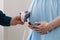 Conceptual photo of couples hands holding baby shoes. Pregnant woman in dress on white background. Pregnancy, maternity, preparati