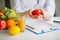 Conceptual Photo Of A Female Nutritionist With Fruits On The Desk