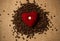 Conceptual photo of red heart lying on pile of coffee beans