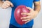 Conceptual photography. The man holds a red ball near his belly, which symbolizes bloating and flatulence. Then he brings a needle