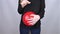 Conceptual photography. The woman holds a red ball near his belly, which symbolizes bloating and flatulence. Then she brings a nee